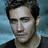 Two side-by-side pixelated images of a person with dark hair, one in color showing blue background and the other in grayscale.