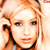 Pixelated static image of a person with light brown hair and dark eyes, cropped to show upper face and shoulders against a bright background.