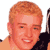 Pixelated static image of a person with light brown hair and fair skin wearing a black sleeveless top, cropped to show upper shoulders and head against white background.