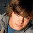 Pixelated image of a person with brown hair wearing a blue shirt and gray jacket, with text "I Luv" above the head.