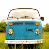 Static image of a light blue van front view with 'Love' text on the hood, orange side markers, round headlights, and a white bumper against a grassy background.
