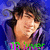 Pixelated portrait of a person with dark hair against blue background, wearing green and purple clothing.