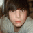 A pixelated image of a person with brown hair and a light gray sweater on the left, next to a black background with pink pixelated text reading "I Love Tyler" and a small pink symbol below.