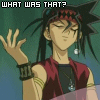 Animated character with spiky black hair and red headband gestures with raised hand against green background, text changes above head.