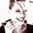 Pixelated static image of a person's face with brown hair and dark clothing, rendered in low-resolution grayscale tones on white background.