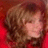 Pixelated static image of a person with light brown hair against a red background, showing partial facial features and a blurred body.