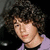 A pixelated image of a person with curly hair on the left, next to purple containing text and a gray