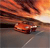 A pixelated image of a red car on a road at sunset with orange and yellow sky, dark clouds, and a white line on the road.