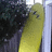 Pixelated image with a yellow surfboard and dark foliage on the left, blue background text reading 'this is my surfboard her name is Sunny Dont you wish she was yours ???'.