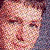 A pixelated close-up of a person's face with warm-toned skin, dark eyes, and a neutral expression against a blurred background.