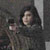 Pixelated static image of a person with dark hair holding a light-colored object against a dark background.