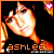 A pixelated animated buddy icon featuring a woman with long blonde hair and dark bangs, shown in two frames of an animation sequence with visible text "ashlee" at the bottom left and a pink heart symbol in the top right corner.