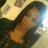 Pixelated image of a person with long dark hair wearing an orange top against a light background.