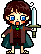 Pixel art character with brown hair and blue eyes holds a white sword in left hand, wearing dark green cloak over brown outfit with green gem at neck.
