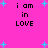 Bright pink background with scattered light blue plus signs and four identical text blocks reading 'i am in LOVE' in black pixelated font.