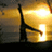 Silhouette of a figure with outstretched arms against a bright yellow-orange background with a glowing light source.