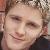 Static pixelated image of a person's face with light skin tone, brown hair, and closed eyes showing subtle smile.