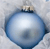 A static pixelated image of a blue spherical object with a light-colored top and dark blue base against a light gray background.