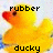 A yellow rubber duck with a red beak and brown eyes appears in two side-by-side frames, each displaying different text above and below the duck.