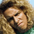 A pixelated image of a person with long curly blonde hair and green clothing, alongside a winged logo reading 'LODS' vertically.