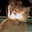 Pixelated static image of a cartoon character with brown hair and light skin, partially obscured by bright lighting effects against a dark background.