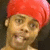 A pixelated figure with a red turban and light skin tone, showing two sequential facial expressions with mouth positions changing from closed to open.
