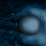 A hand holds a spherical object that transforms into a detailed eye with blue and white rings, then reverts to a sphere.