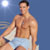 Static pixelated image of a shirtless man in light blue swim trunks standing against a gradient background with a bright circular highlight on the left.