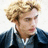 Pixelated image of a person with light brown curly hair wearing a dark blue jacket over a white shirt, next to pixelated text reading 'what the HALE?' on a white background.