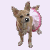A pixelated dog with brown fur and black eyes stands facing forward, holding a pink and white circular object in its mouth against a light purple background.
