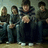 Four pixelated figures stand in a against a muted background, with bold text on the right side