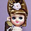 A doll with brown hair styled in an elaborate updo adorned with a white rose, wearing a brown and white outfit with a red accent, shown in three poses against a purple background.