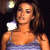 Pixelated image of a person with shoulder-length brown hair wearing a light blue strapless top against a dark background with a bright circular light source.