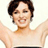 Pixelated static image of a person with short dark hair wearing a light-colored sleeveless top and dark bottoms, arms raised in an energetic pose against a plain background.