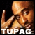 Pixelated static image of a person with light brown skin tone making a hand gesture, featuring visible text at the bottom and a black background.