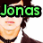 A pixelated image of a person with dark hair wearing a white shirt, dark jacket, and black choker necklace, with green text reading 'Jondas' overlaid on the top-left portion.
