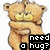Pixelated cartoon cat with light brown fur, large yellow eyes, and a black nose stands in front of a white background holding a black sign that reads "need a hug?".
