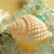 A pixelated static image of a light-colored animal with rounded features, set against a soft-toned background with muted green and brown hues.