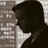 Pixelated grayscale icon showing a person's profile with dark hair and light clothing against a textured background.