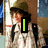A pixelated figure in a green helmet and white uniform with black straps, holding a vertical green bar that changes to a heart shape.