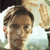 A pixelated close-up of a person with light brown hair and a neutral expression, partially cropped on the left side.