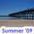 Pixelated beach scene with blue sky, ocean, and pier structure above sandy shore; 'Summer '09' text in blue pixel font at bottom.