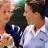 Pixelated static image of two figures in tennis attire with one figure holding a racket, set against a blurred background.