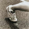 A foot in a white athletic shoe on a textured surface with text reading 'just RUN' below.