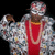 Pixelated figure in red and silver attire with a large chain, raised arm gesture against black background.