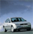 Pixelated image of a white sedan car with dark windows and black wheels against a gradient blue sky background.