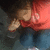 A person in a red shirt and blue jeans appears with their head turned left, then right, against a dark background.