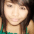 Pixelated close-up of a person with long brown hair wearing a green top, cropped to show shoulders and upper chest.