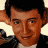 A 48x48 pixel buddy icon split into two frames showing a person with dark hair and a black jacket on the left, and green text reading "Original Icons .com" on a dark green background on the right.