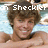 Pixelated static image of a person with brown hair and light skin, wearing no shirt, with text "T. Sheckler" overlaid in white block letters.